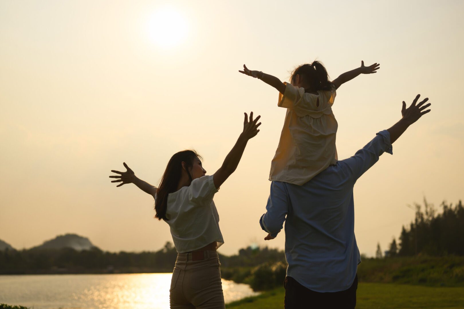 Family enjoying sunset by a lake.