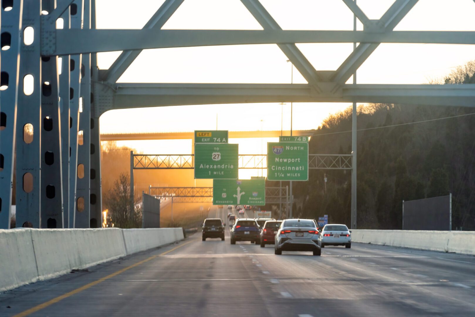 Cars driving on a highway at sunset.
