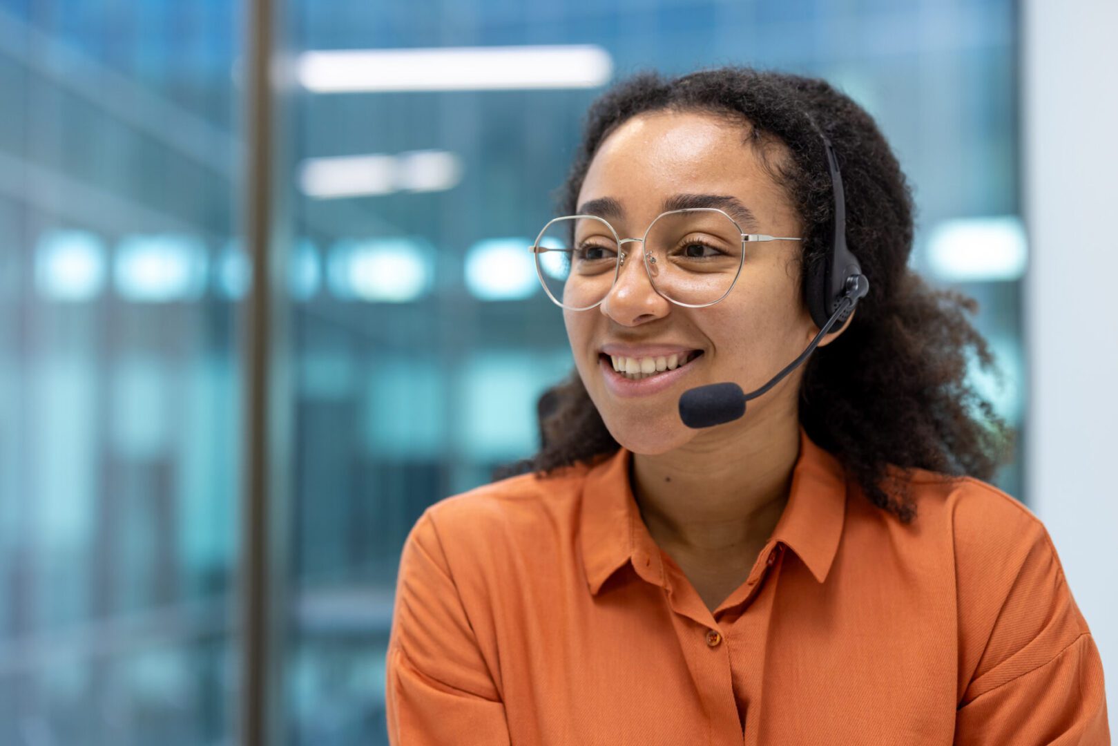 Smiling woman wearing headset in office setting.