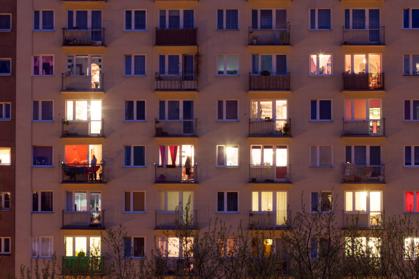 Lit apartment building facade at night.