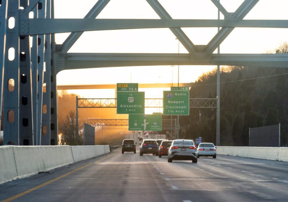 Cars driving on a highway at sunset.